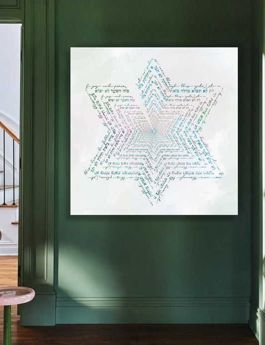 A square wall art birkat habayit print mounted on a wall, featuring a large star-shaped composition made of many small multicolored words on a white background.  