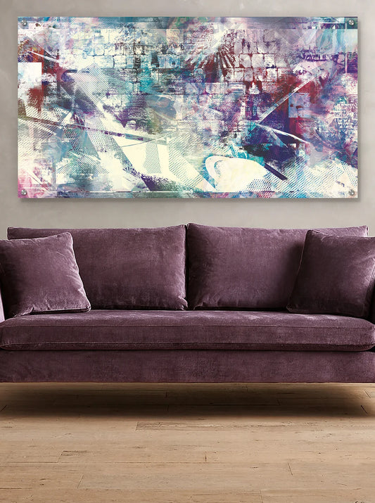 A large rectangular abstract metal wall art of the Kotel with blended blue, purple, white, and gray brushstrokes, displayed above a plush mauve-purple velvet sofa in a modern room with light wood flooring.